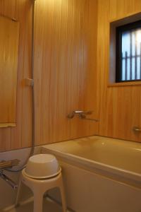 a bathroom with a toilet and a tub and a stool at Sumiyoshiya in Kanazawa