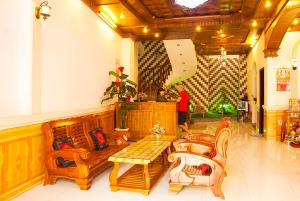 a lobby with wooden furniture and a person in the background at Hoa Mau Don Homestay in Hoi An