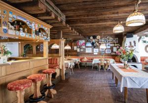 restauracja ze stołami i krzesłami oraz barem w obiekcie Pension Nina & Gasthof Alpenrose w mieście Gschnitz