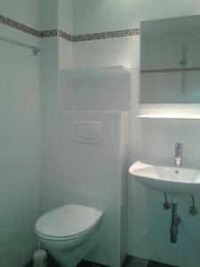 biała łazienka z toaletą i umywalką w obiekcie Strandpension Liane w mieście Sankt Kanzian