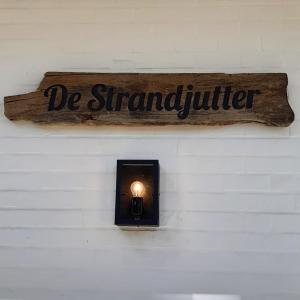 una señal en una pared con una luz en ella en Villa De Strandjutter en Nieuwpoort