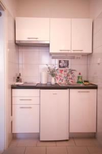 una cocina con armarios blancos y encimeras negras en House Bilic, en Baška Voda