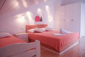 1 dormitorio con 2 camas con sábanas rojas en House Bilic en Baška Voda