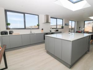 eine Küche mit weißen Schränken und einer großen Insel in der Unterkunft Rosemary Cottage in Chathill