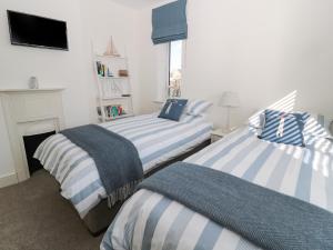 zwei Betten in einem Zimmer mit Kamin in der Unterkunft Rosemary Cottage in Chathill