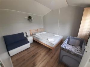 a small room with a bed and a couch at Domki na Mazurach "Malinka" in Suchy Róg