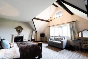 a bedroom with a bed and a couch and a chair at Weston Hall in Stafford