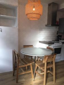 a kitchen with a table and chairs and a refrigerator at London Spacious Apartment by DC London Rooms in London