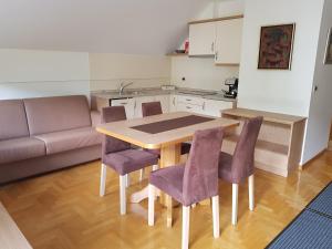 a kitchen and dining room with a table and purple chairs at Apartment Brumec in Bohinj