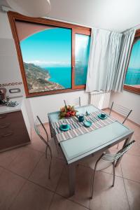 a table and chairs in a kitchen with a view of the ocean at Nonna Carmelina in Ravello