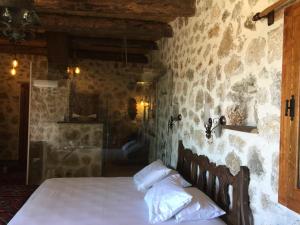 a bedroom with a bed and a stone wall at Beso Patara in Patara