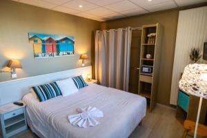 a bedroom with a bed with a bow on it at The Originals Boutique, Hôtel Neptune, Berck-sur-Mer in Berck-sur-Mer