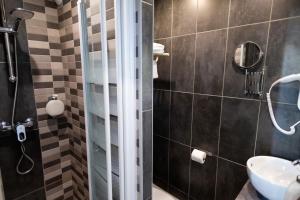 a bathroom with a shower and a sink at The Originals Boutique, Hôtel Neptune, Berck-sur-Mer in Berck-sur-Mer
