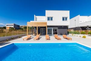 a villa with a swimming pool and a house at Villa Belveder in Pag