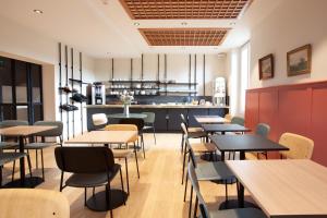 アンジェにあるグラン ホテル ドゥ ラ ガルのテーブルと椅子のあるレストラン、キッチンが備わります。