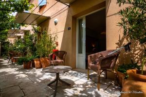 um pátio com cadeiras e uma mesa em frente a uma porta em Hotel Les Restanques De Moustiers em Moustiers-Sainte-Marie