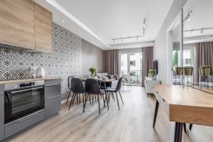a kitchen and dining room with a table and chairs at PREMIUM Apartments New Town Private Parking Included in Szczecin