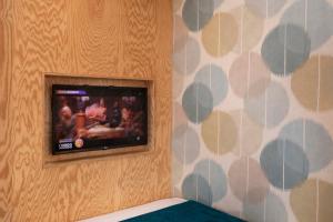a flat screen tv on a wall in a room at Hôtel LOCOMO in Paris