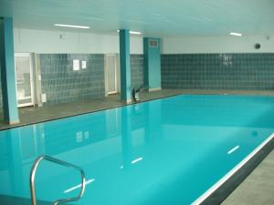 a swimming pool with blue water in a building at ferienwohnungen-bendler in Freyung