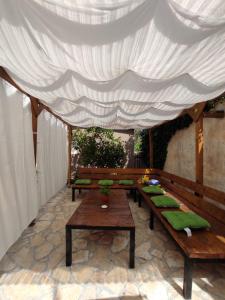 a group of benches with green pillows under a canopy at Apartment Amans 1 in Pula