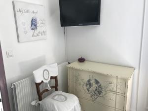 esquina de una habitación con TV y silla en O Mylle Douceurs, en Le Crotoy