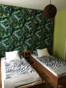 2 Betten in einem Zimmer mit einer großen grünen Wand in der Unterkunft Gasthaus Zum Stadtwald in Rottenmann