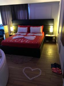 um quarto com uma cama com um coração desenhado no chão em Hotel Golden em Shkodër