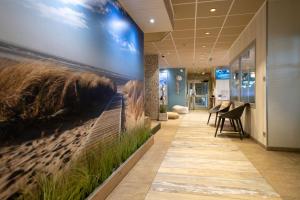 an office lobby with a wall mural of a train at The Originals Boutique, Hôtel Neptune, Berck-sur-Mer in Berck-sur-Mer