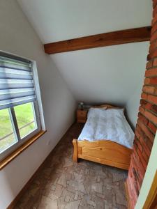 a small bedroom with a bed and a window at Domek Klimkówka in Klimkówka