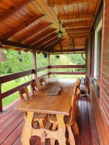 a wooden table on the back porch of a cabin at Domek Klimkówka in Klimkówka