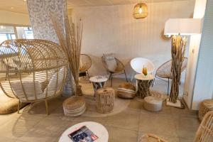a room with chairs and tables in a room at The Originals Boutique, Hôtel Neptune, Berck-sur-Mer in Berck-sur-Mer