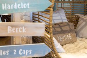 a store window with a bunch of signs and pillows at The Originals Boutique, Hôtel Neptune, Berck-sur-Mer in Berck-sur-Mer