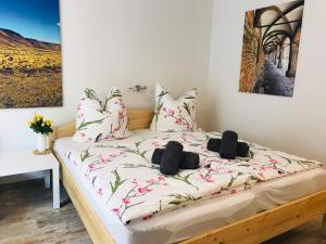 een slaapkamer met een bed met roze bloemen erop bij Appartement Eichhörnchen - zentral Todtmoos Schwarzwald Black Forest in Todtmoos