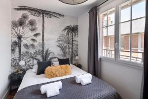 a bedroom with a bed with palm trees on the wall at Carré Sainte-Anne - Appt en plein centre historique in Rennes