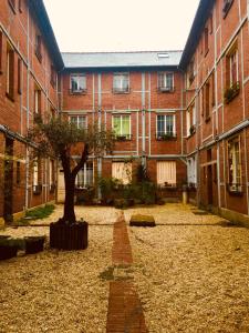 a courtyard with a tree in the middle of a building at Carré Sainte-Anne - Appt en plein centre historique in Rennes