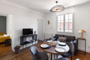 uma sala de estar com mesa e cadeiras em Carré Sainte-Anne - Appt en plein centre historique em Rennes