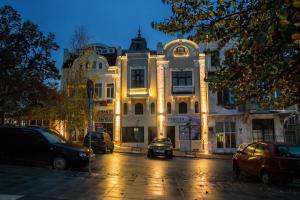 a large white building with cars parked in front of it at MiTRa Luxury Apartments in Shumen