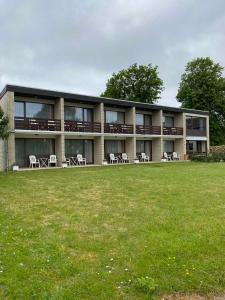 ein Gebäude mit Tischen und Stühlen auf einem Feld in der Unterkunft Sonnenstrand Hotel in Butjadingen