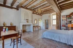 een slaapkamer met een bed, een bureau en een open haard bij Le Castel in Montigné-les-Rairies