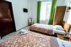Una habitación de hotel con dos camas y un televisor. en Green House, en Bucarest