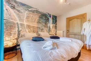1 dormitorio con 1 cama blanca grande con almohadas azules en Le Domaine de Wisbeley, en Halet