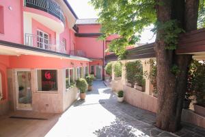 an empty courtyard of a pink building with a tree at Boutique Hotel Asteria in Ljubljana
