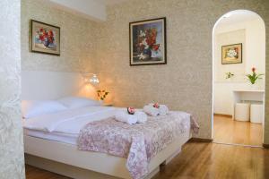 a bedroom with two stuffed animals sitting on a bed at Boutique Hotel Asteria in Ljubljana