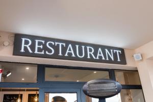 a restaurant sign on the front of a store at The Originals Boutique, Hôtel Neptune, Berck-sur-Mer in Berck-sur-Mer