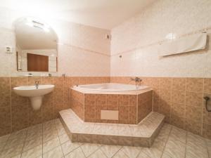 y baño con bañera y lavamanos. en Penzion Atlas, en Liptovský Mikuláš
