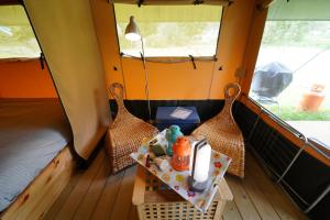 Cette chambre comprend un lit, deux chaises et une table. dans l'établissement Safaritent op Camping Berkel, à Bockholtz