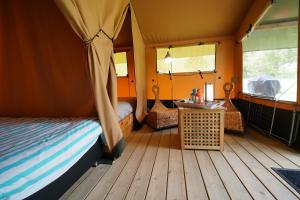 een slaapkamer met een bed en een tafel in een tent bij Safaritent op Camping Berkel in Bockholtz