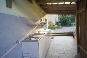eine Küche mit 3 Waschbecken und einer offenen Tür in der Unterkunft Safaritent op Camping Berkel in Bockholtz