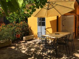 a table and chairs with an umbrella on a patio at Appartamenti Tina Paolini 1 piano terra con parcheggio in Castiglione della Pescaia