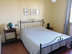 a bedroom with a bed with a blue and white comforter at Agriturismo Poggio Sassineri in Magliano in Toscana